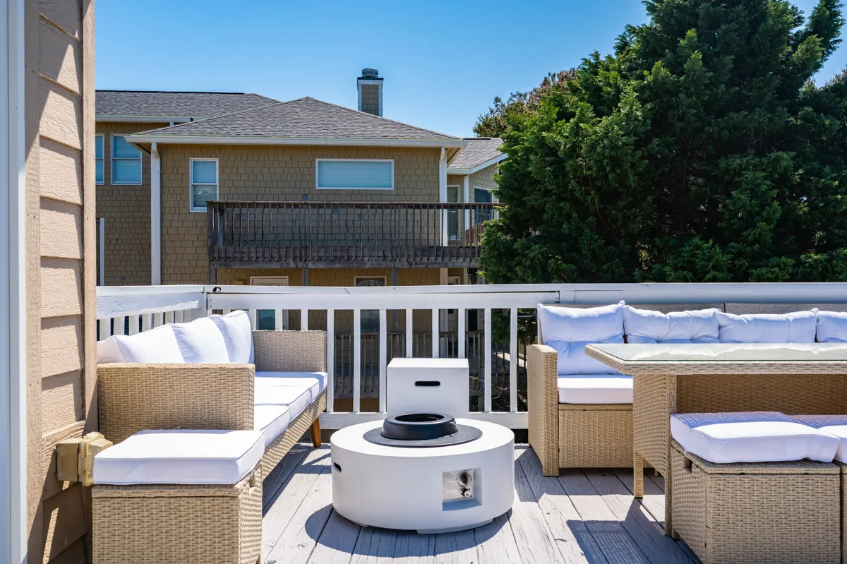 This exterior scene features a welcoming fire pit surrounded by comfortable outdoor seating, set amidst lush greenery. The space invites guests to gather, socialize, and enjoy evenings under the stars—perfect for s'mores and storytelling.