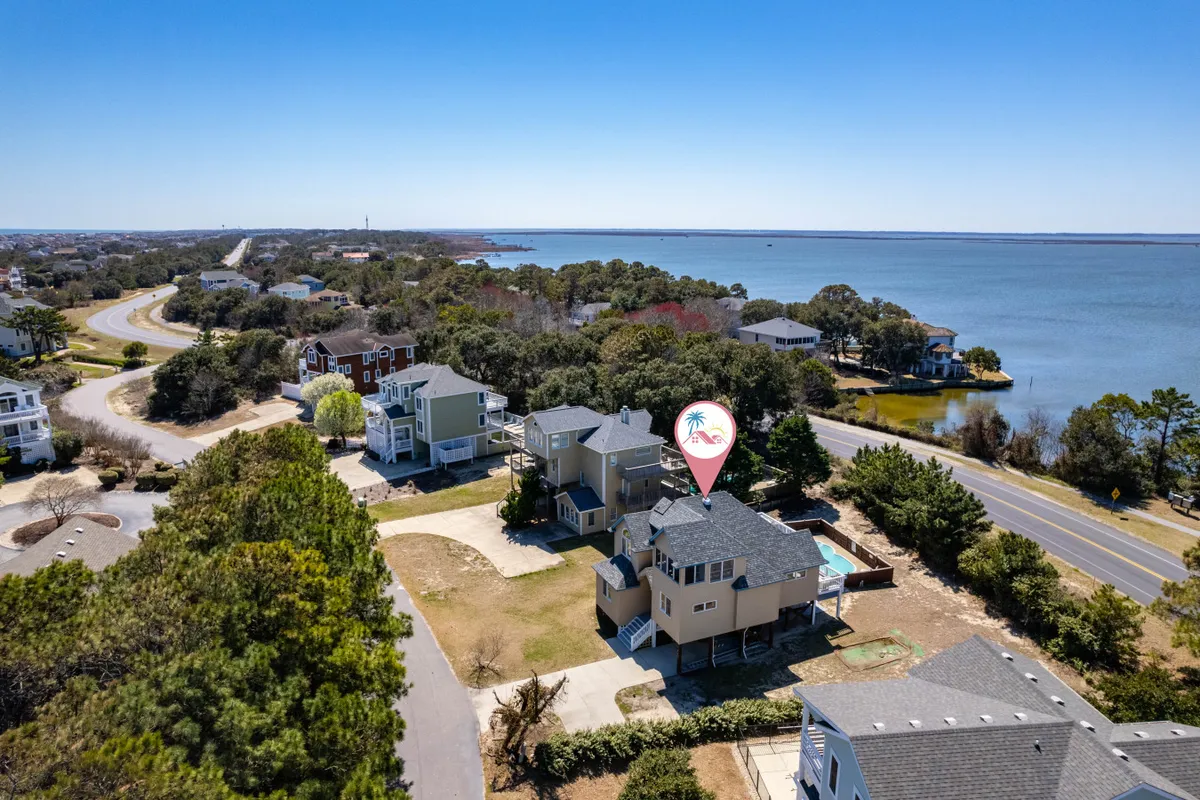 A relaxing waterfront view with lush greenery and a sense of neighborhood layout. The image captures the essence of relaxing by the shore, boating, fishing, or strolling through the local area at sunset or sunrise.